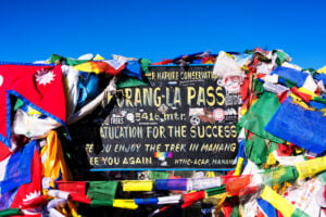 Tibetan pile of stones and colored flags on the pass, Himalayas, Nepal. Thoroang La Pass.