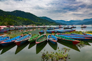 Colorful long tail boats on Phewa lake in Pokhara, Nepal with mountain view