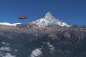 Ultralight plane flies over Pokhara and Machapuchare in Annapurna region, Nepal