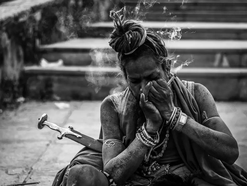 Holy men smoking on concrete pavement - Maha Shivaratri 